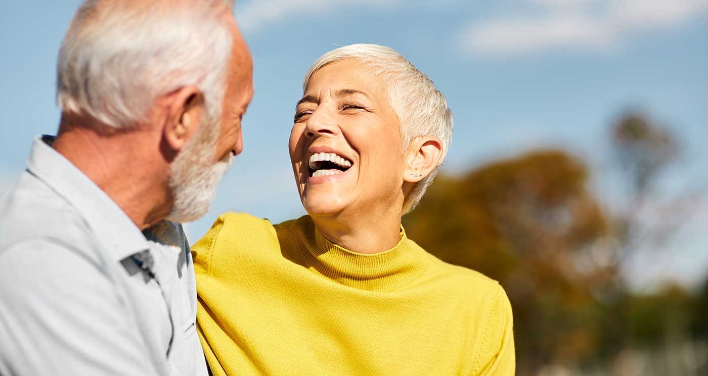 Older couple outdoors and laughing