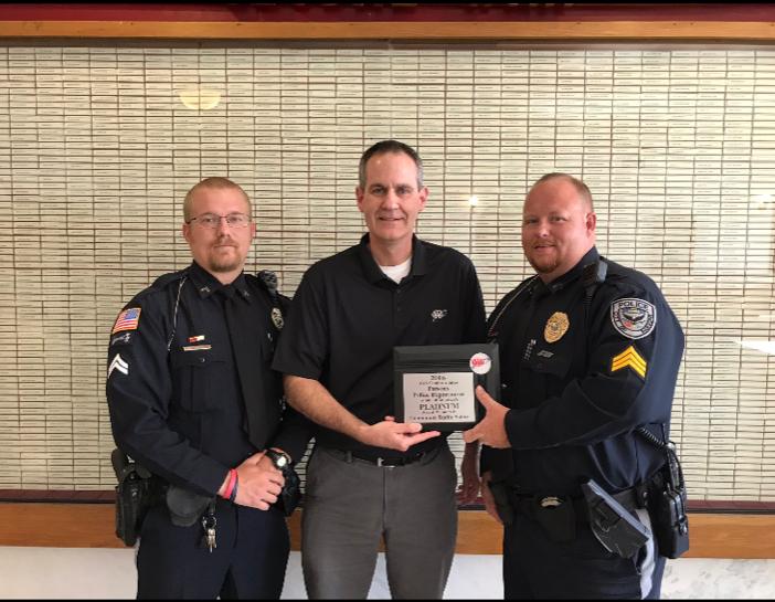 Two Parsons PD officers presenting a placard.
