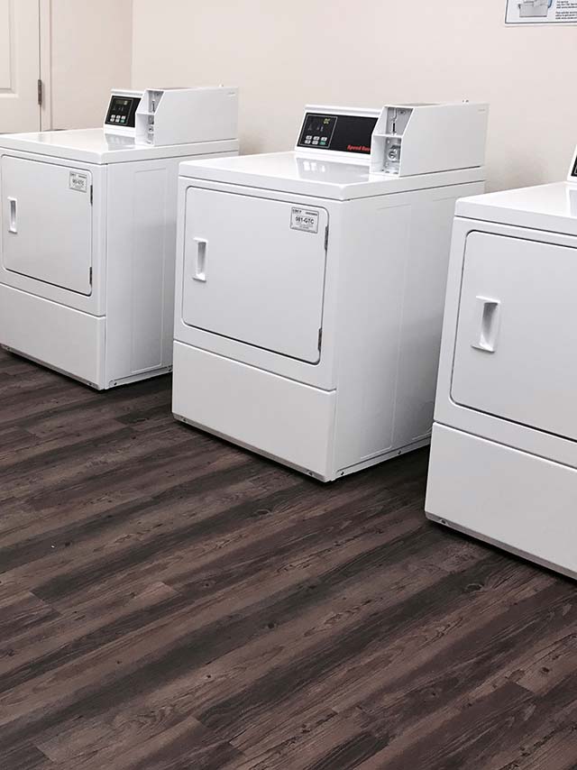 A laundry room showing washing machines and dryers.