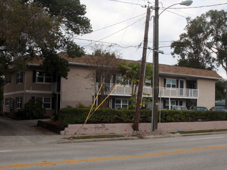 A tan home with a medium sized yard.