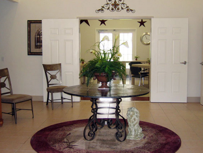 A dining room with a table in the center.