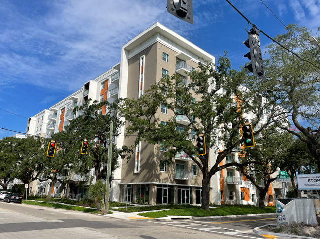 Gray building surrounded by trees.