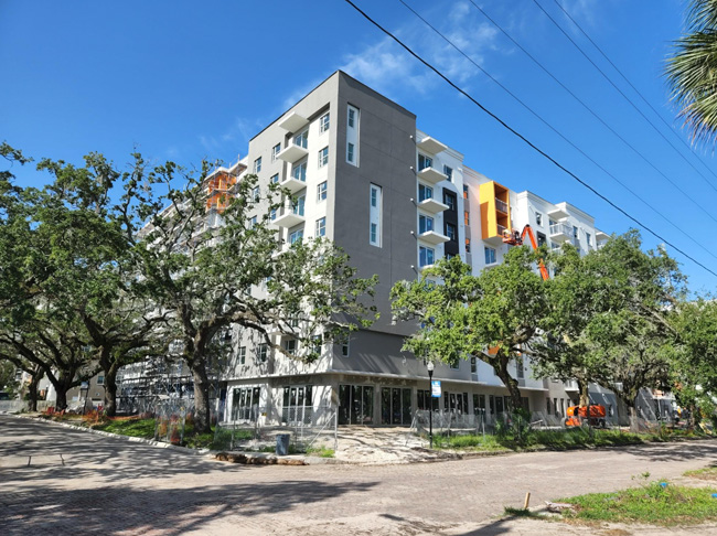 Tower 4 West River Building surounded by trees and sidewalks.