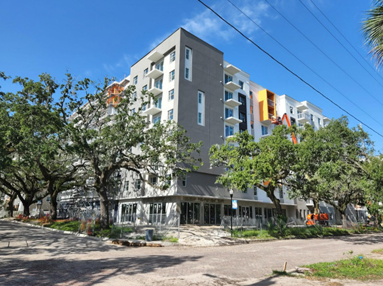 A large gray and white building surrounded by trees.