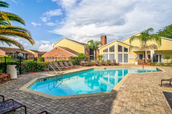 A pool area surrounded by a brick walkway.