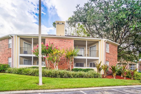 Meridian Apartments building showing trees and bushes growing on the side.