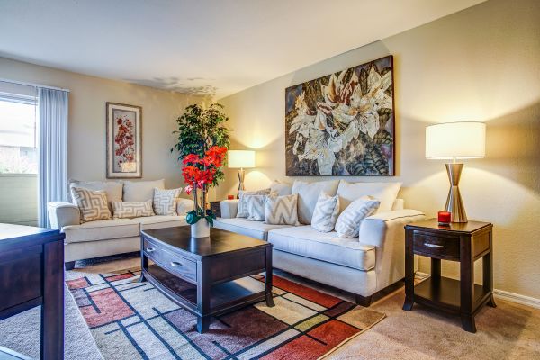 A living room area with sofas and night stands.