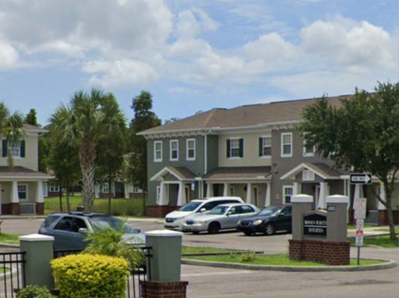 Apartment complex with a large parking lot.