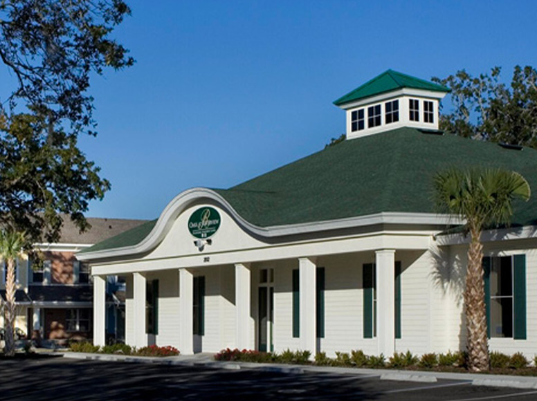 A white building with a green roof.