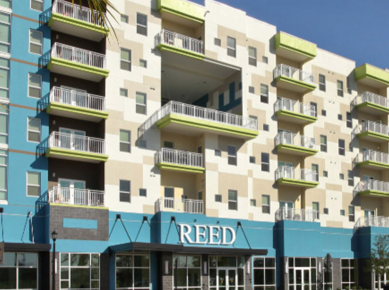 An apartment building with balconies and large lettering that reads Reed.