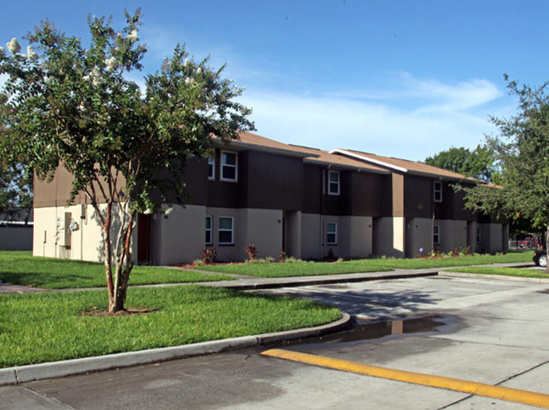 A brown and white home with a large front yard.