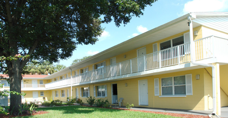 Yellow Apartment building with  a white balcony.