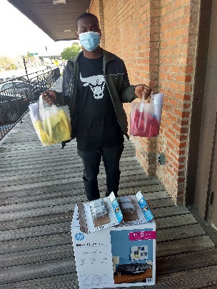 A student holding two plastic bags.