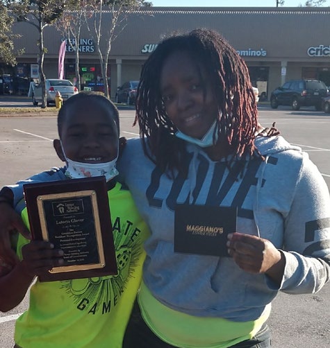 an individual holding a Geraldine Barnes Award.