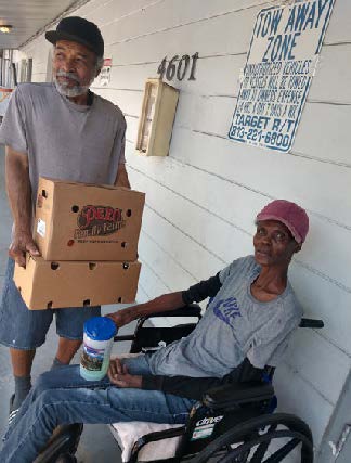 Individual holding a box of food.