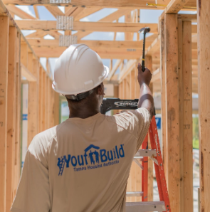 A carpenter is pictured holding a hammer about to swing. 