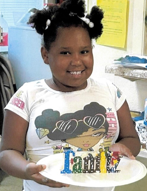 Attendee of the 2024 summer camp holding her project.