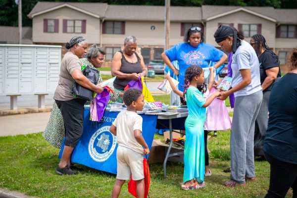 Families helping children receive books. 