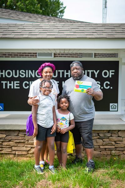 Family holding up a free book. 