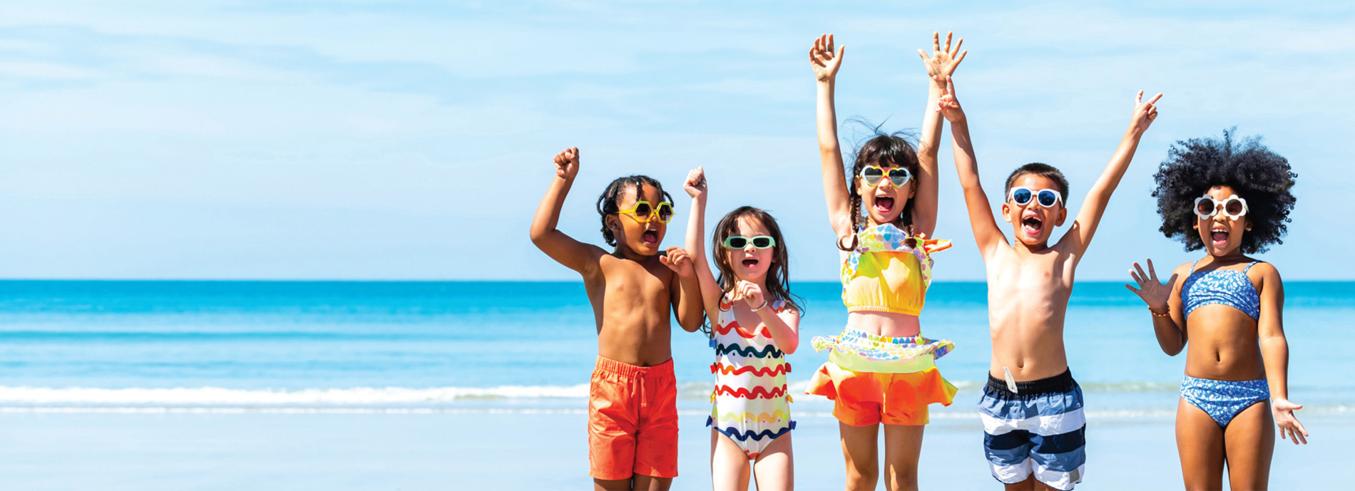 Five children playing in the ocean.