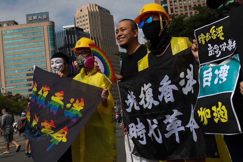 挺香港反送中的民眾上街參與遊行，持布條看板表達訴求（圖/中央社）