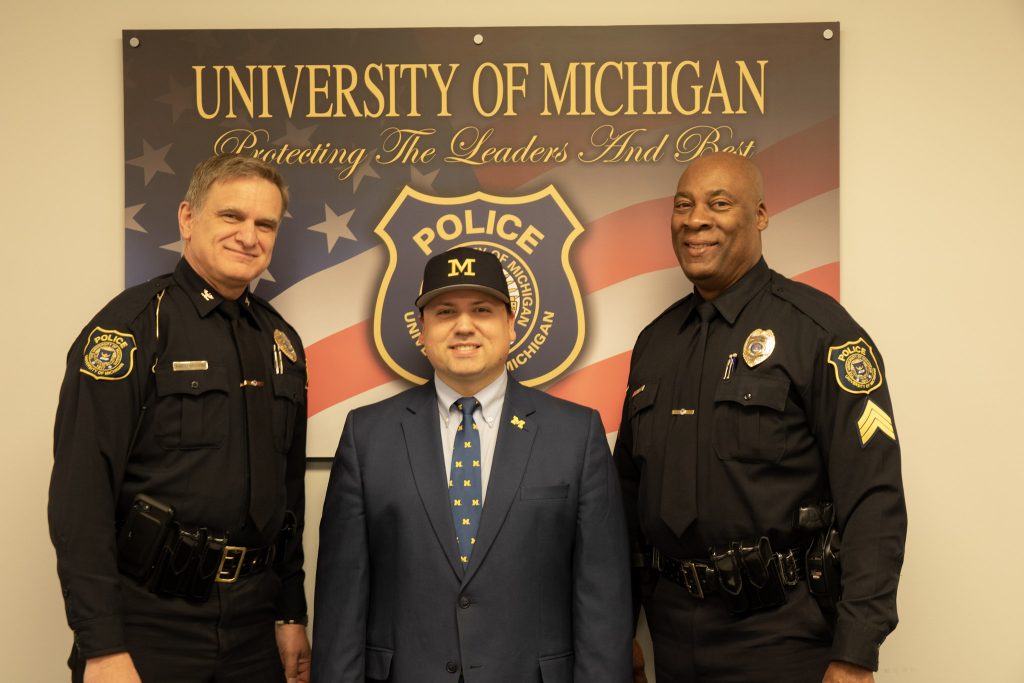 U-M Police Chief Robert Neumann, advocate Xavier DeGroat and Sgt. Gary Hicks pose for a photo at the U-M Police Department in January 2020.