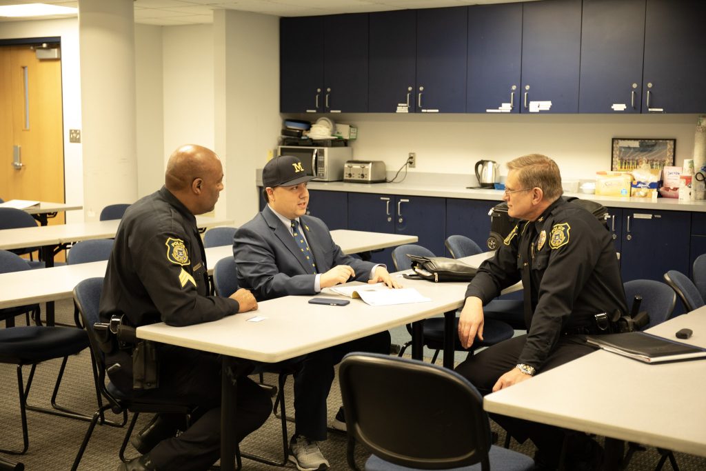 U-M Police Chief Robert Neumann, advocate Xavier DeGroat and Sgt. Gary Hicks pose for a photo at the U-M Police Department