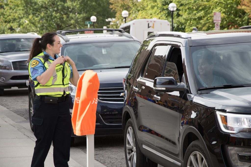 Michigan Medicine Security Officer welcoming parents and student during student move in