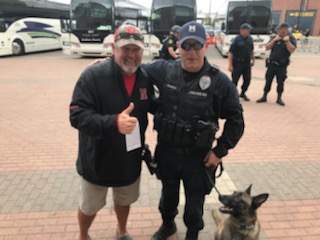 Larry the Cable Guy standing to the left of Officer Dunny and K9 Tank with thumbs up and left arm around the back of Officer Dunny