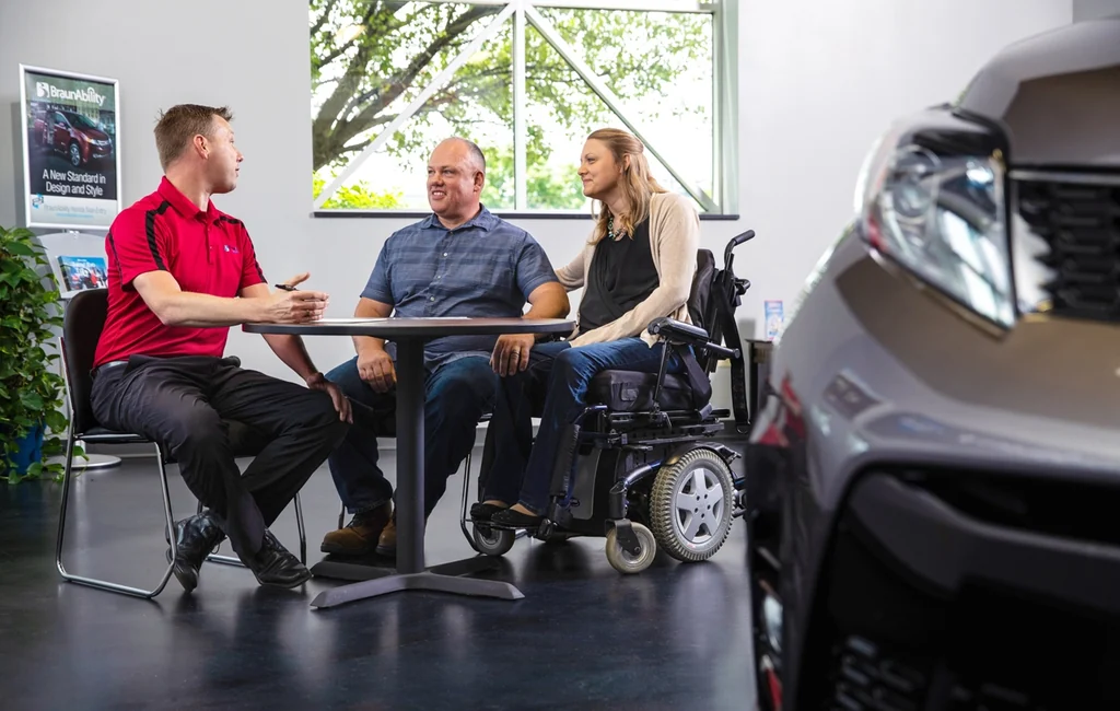 Mobility consultant reviewing financing options with a couple at a dealership