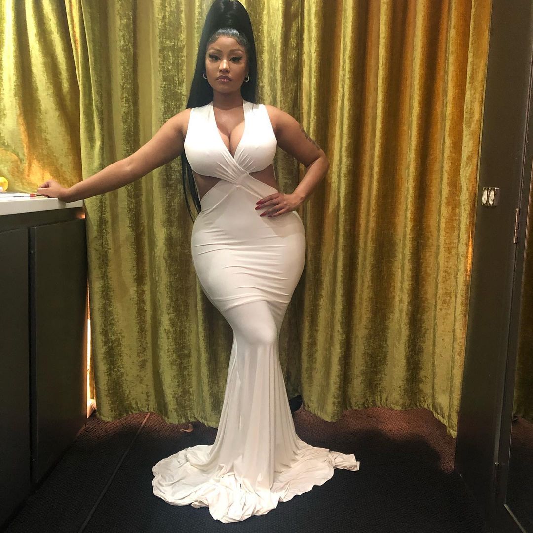 Nicki Minaj looks absolutely gorgeous in this white floor-sweeping dress at an event and her hair is boldly styled into a high ponytail.