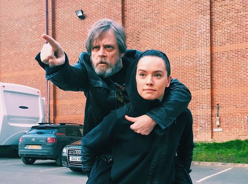 Mark Hamill is getting a piggyback ride by Daisy Ridley.