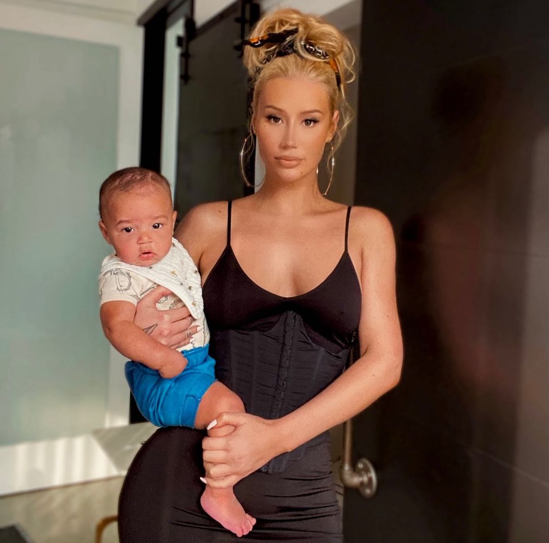 A photo showing Iggy Azalea in a black outfit, and baby Onyx, firmly sitted on her waist area.