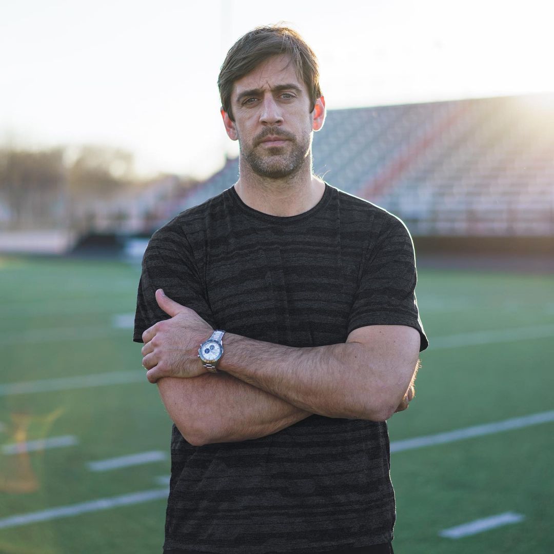 Aaron Rodgers looks amzing in this gray-black shirt on a large field.