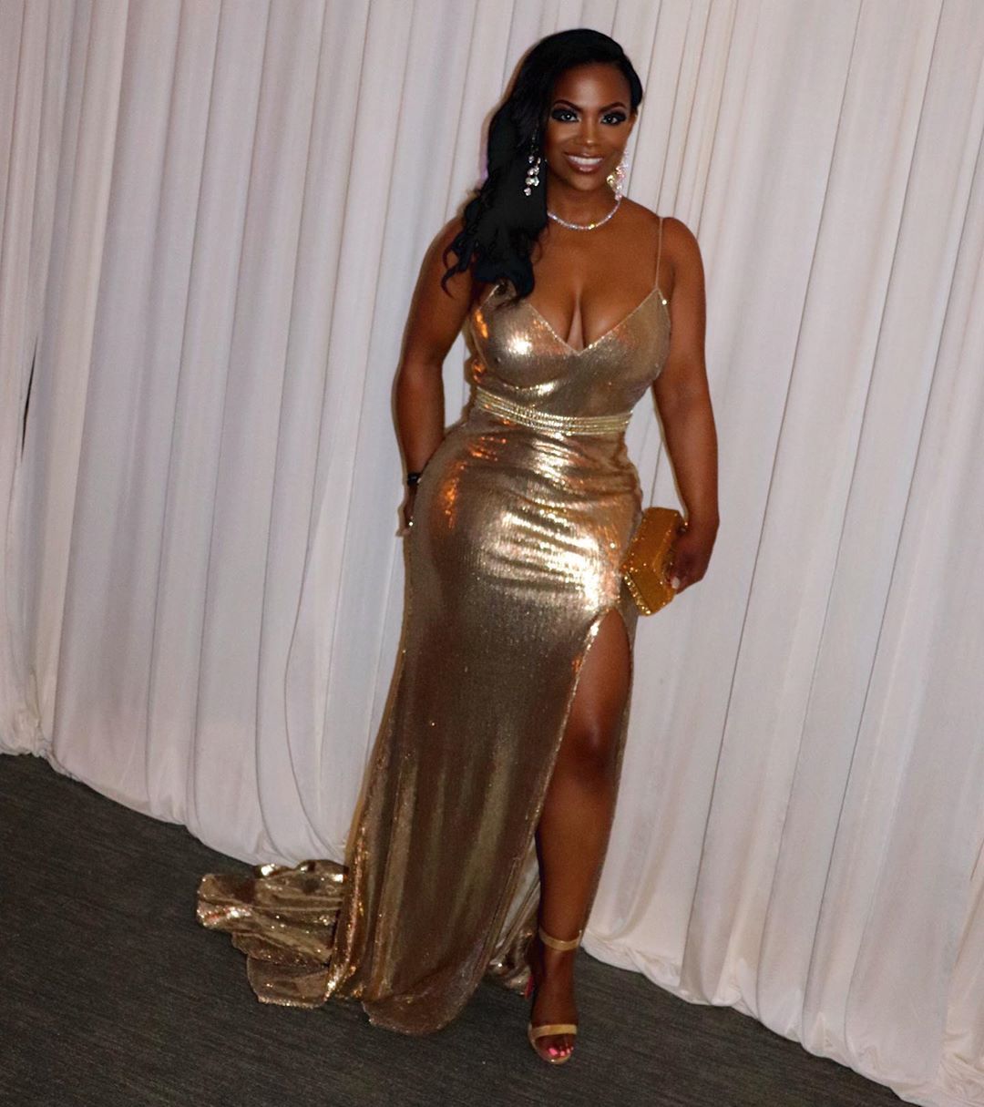 Kandi Burruss wears a low-cut gold dress.