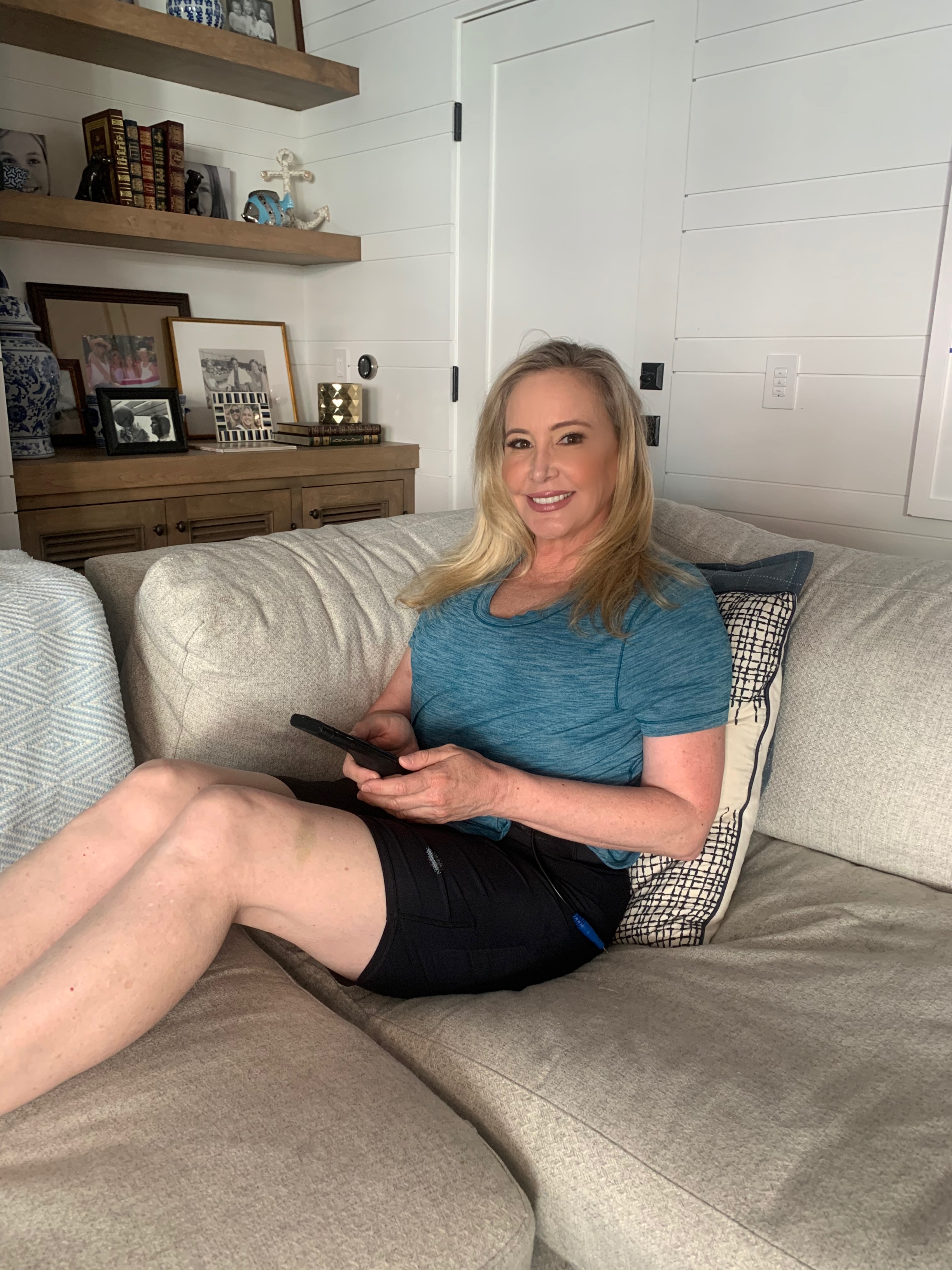 Shannon Beador sits on a couch in a blue T-shirt.