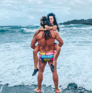 Brock Davies holds Scheana Shay in the water in Hawaii.