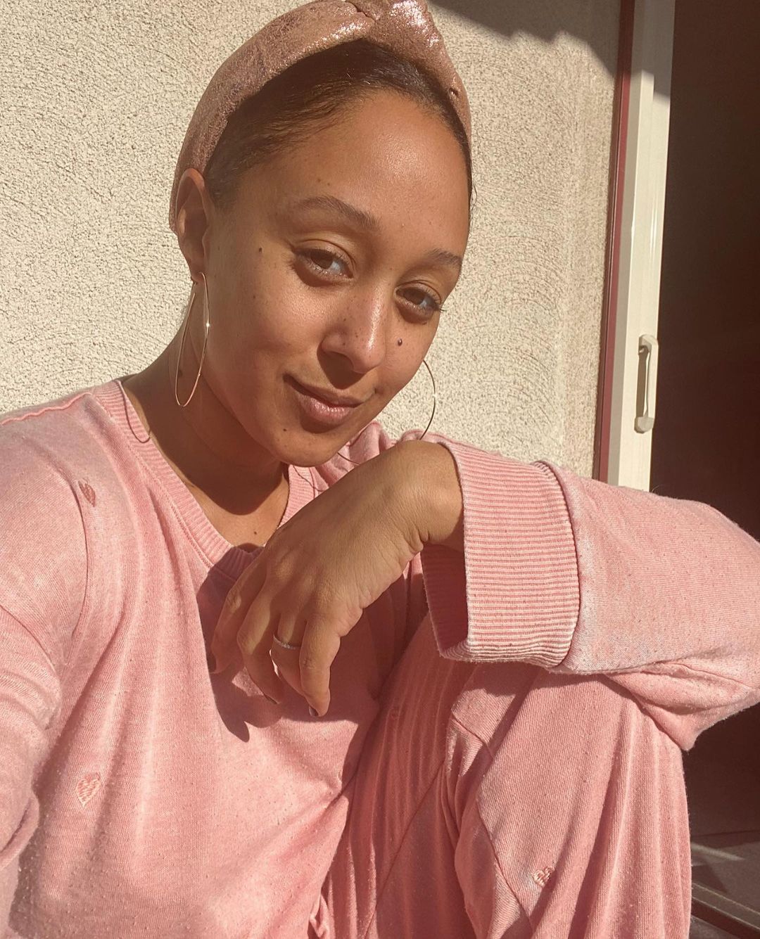 An amazing photo showing Tamera Mowry-Housley in a plain pink two-piece outfit, soaking up the sun and she looks incredible.