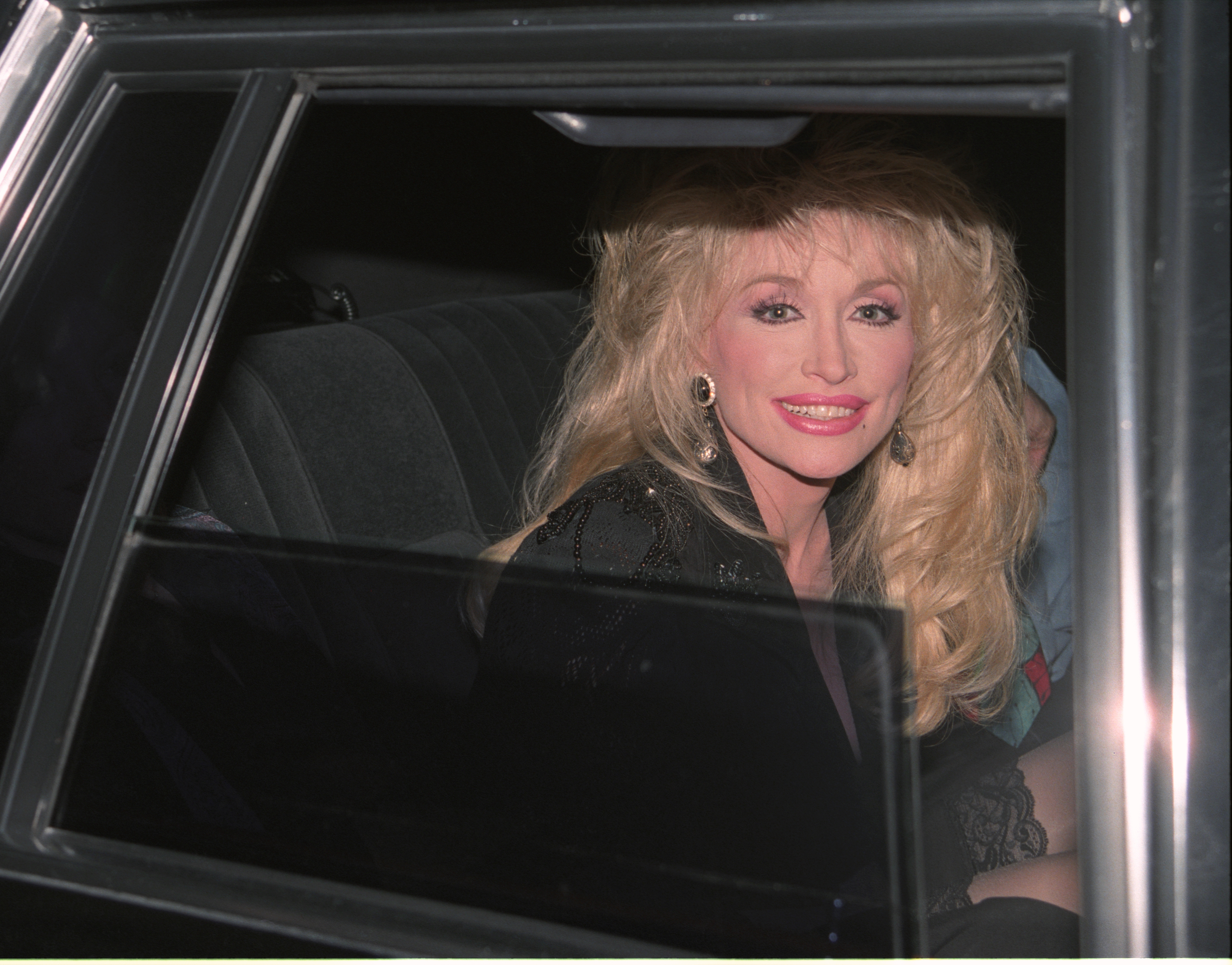 Dolly Parton when she was younger, sitting in a car. 