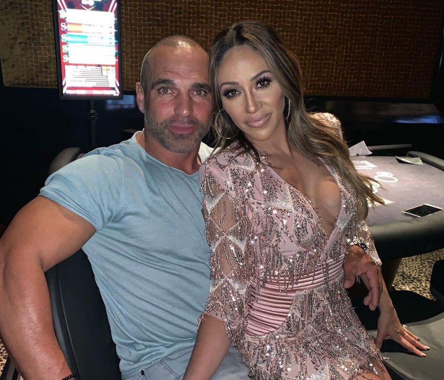 Melissa Gorga wears a low-cut pink and silver gown on Joe's lap.