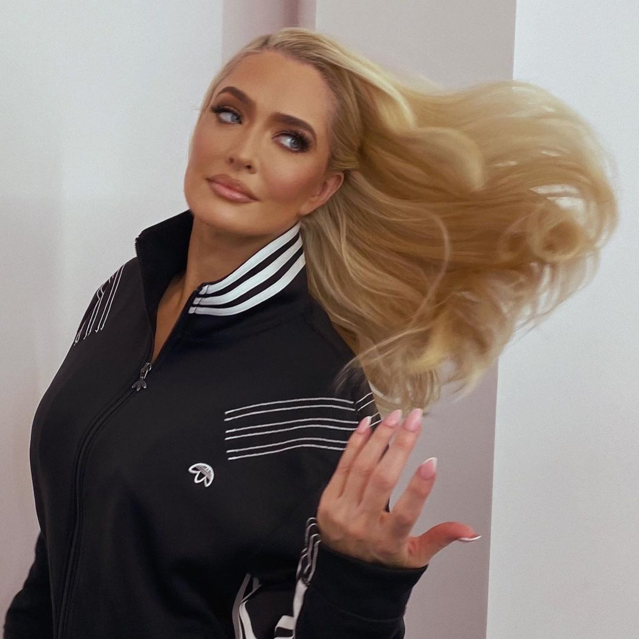 Erika Jayne wears a varsity-style jacket and flips her hair.