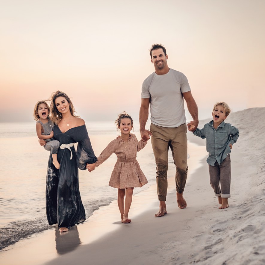 Jessie James Decker with her husband and chiildre walking on the beach.