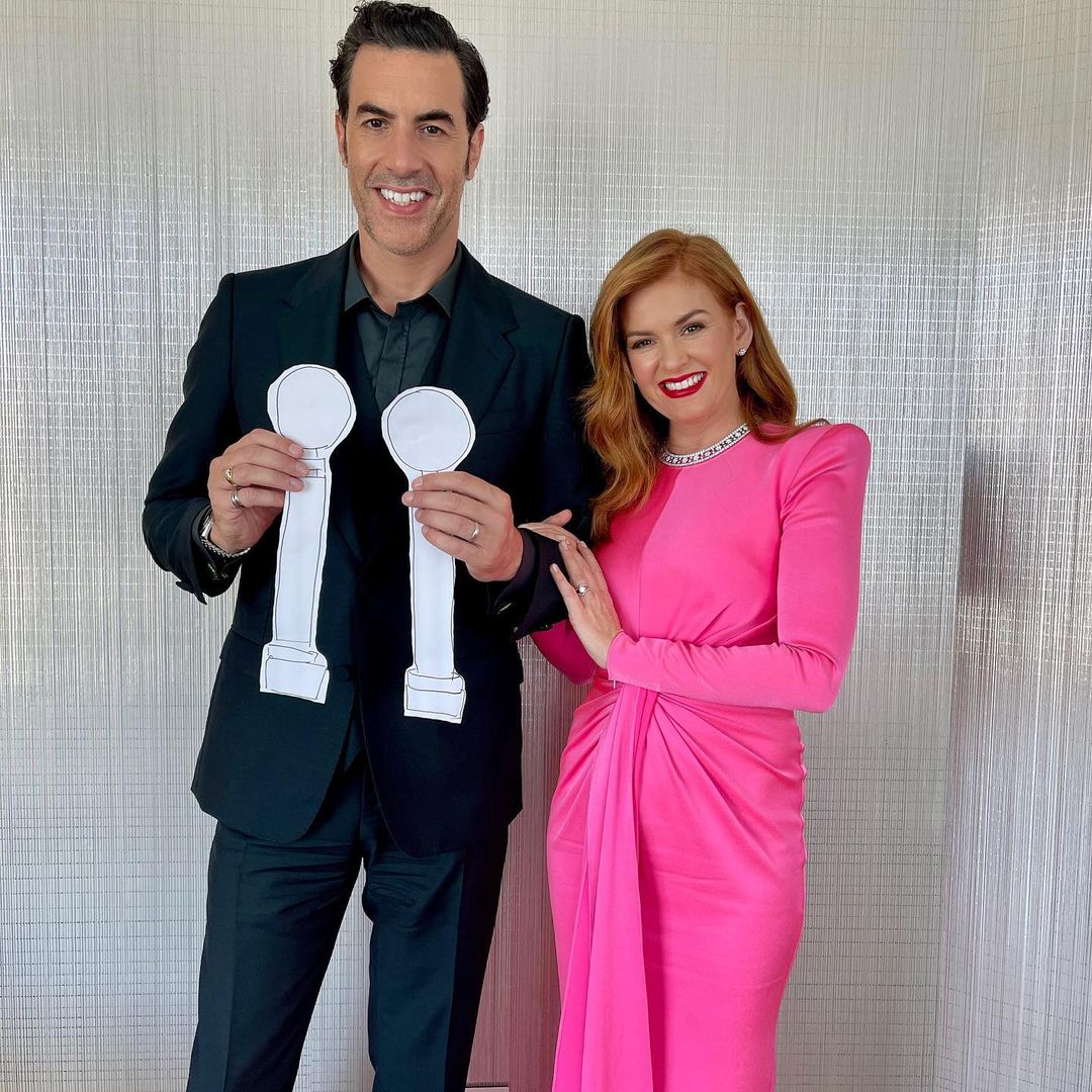 Sacha Baron Cohen and his wife, Isla Fisher looks awesome in this photo, showing them in a black and pink outfit respectively.