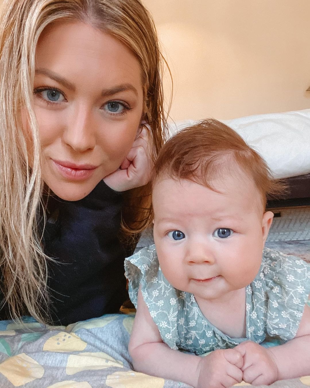 Stassi Schroeder sits on her elbows with daughter Hartford.