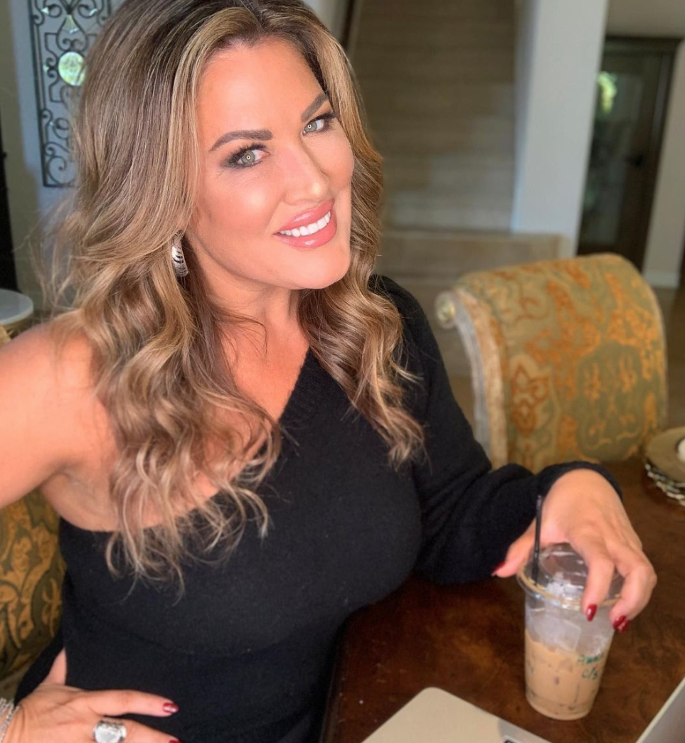 Emily Simpson enjoys a coffee in a black outfit.