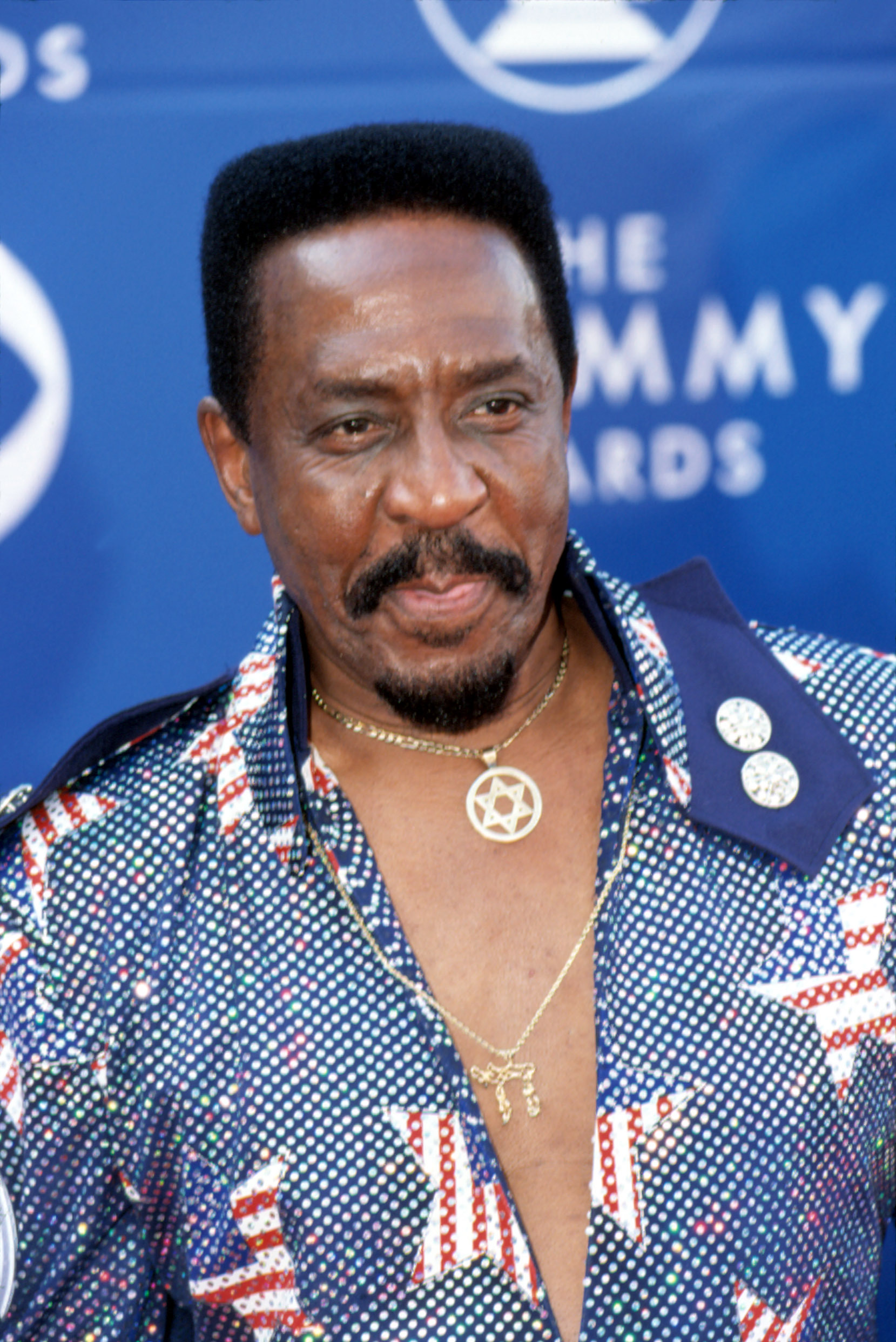 A photo of Ike Turner in blue and white polka dot design T-shirt at an event.