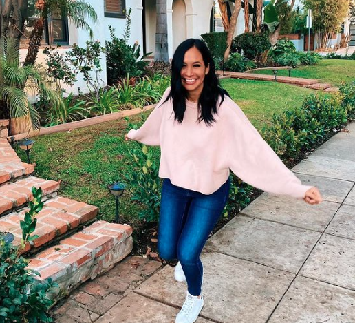 Jo De La Rosa skips down a California street in a pink sweatshirt.