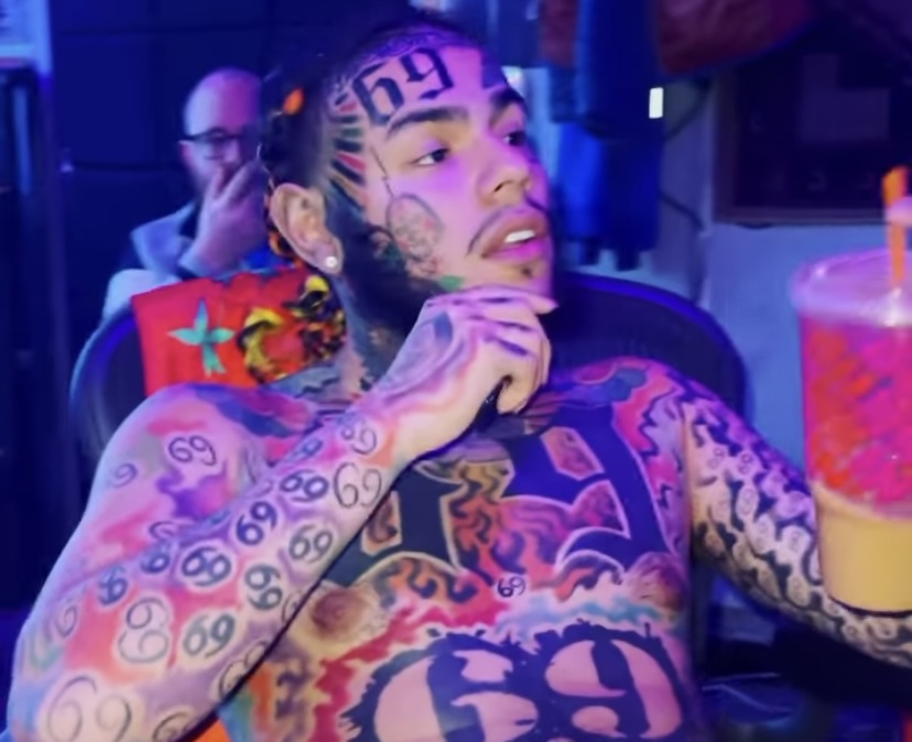 6ix9ine showing off all of of tattoos while in the studio.
