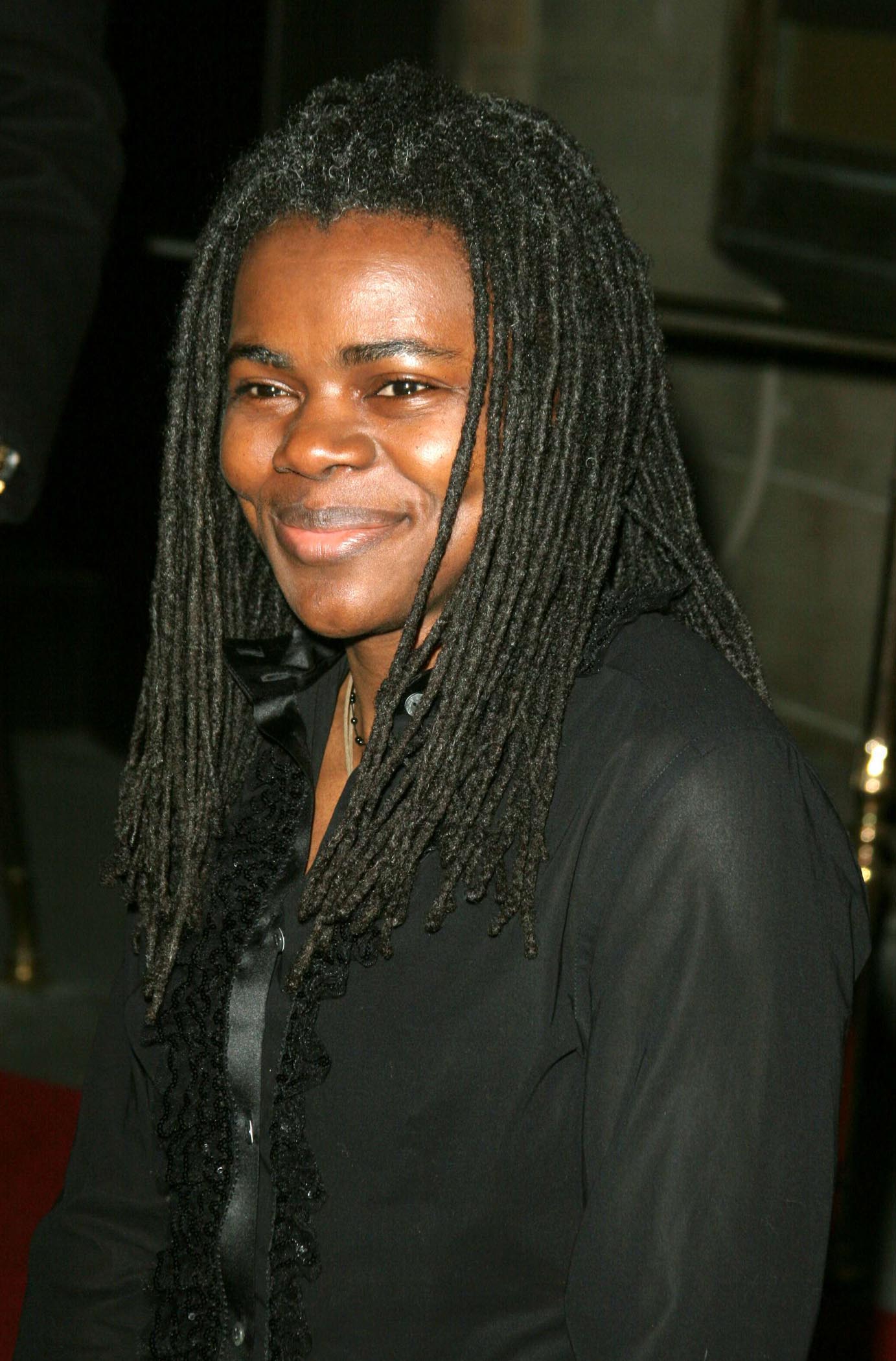 Tracy CHapman looks amazing with her dreads and black outfit at an event and also check out her lovely smile.