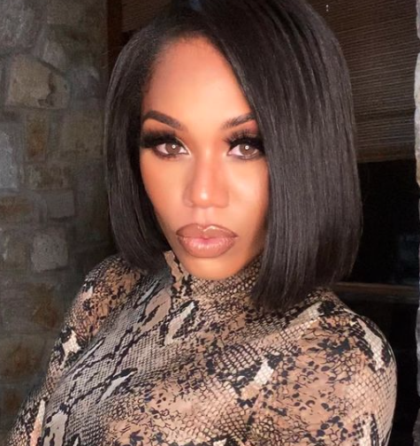 Monique Samuels wears an animal-print turtleneck.